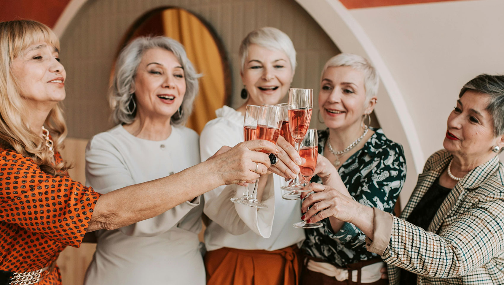 a group of women enjoying a glass of pink champagne