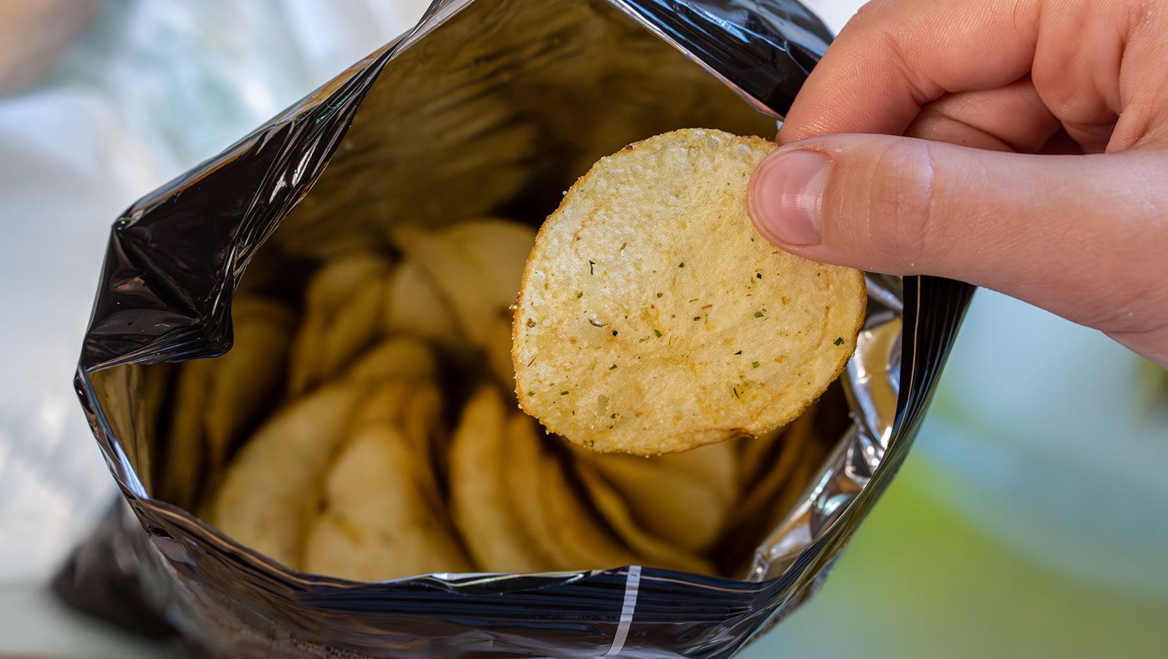 Person eating from bag of chips