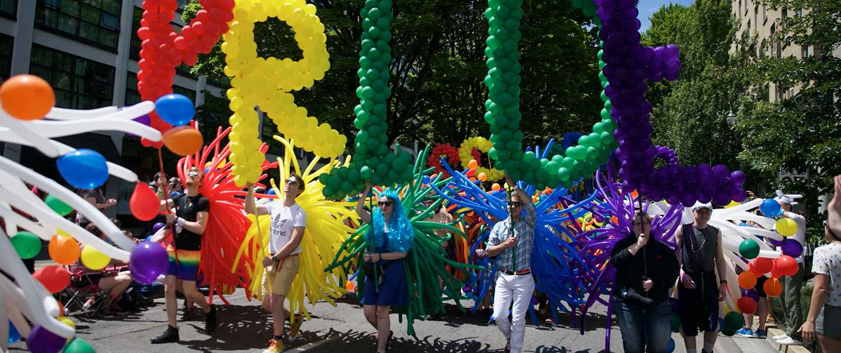 Pride Parade attendees with rainbow balloons